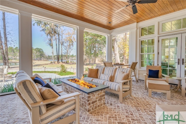 sunroom / solarium featuring a wealth of natural light, wooden ceiling, french doors, and ceiling fan