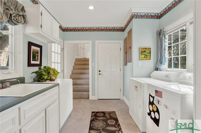 laundry area with sink, cabinets, light tile patterned floors, washing machine and clothes dryer, and crown molding