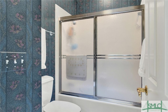 bathroom with enclosed tub / shower combo and toilet