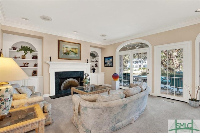 carpeted living room with crown molding and built in shelves