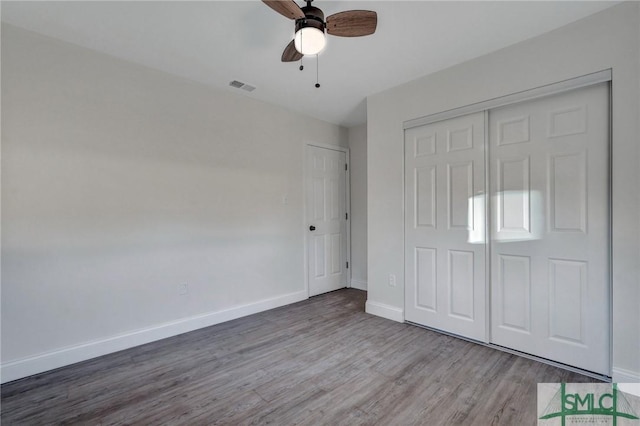 unfurnished bedroom featuring wood-type flooring, a closet, and ceiling fan