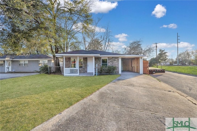 single story home featuring a front lawn, a carport, and covered porch