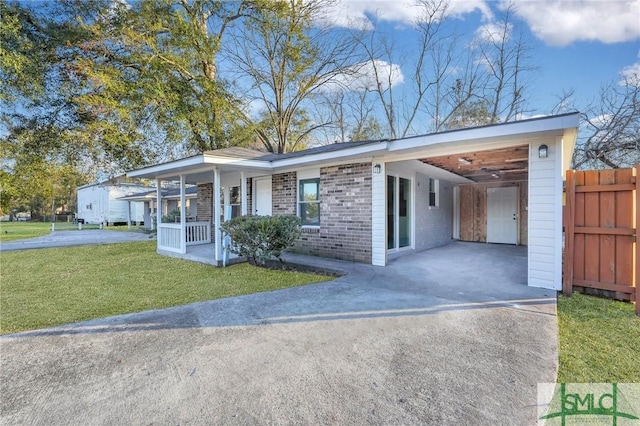 view of front facade with a front lawn, a carport, and covered porch