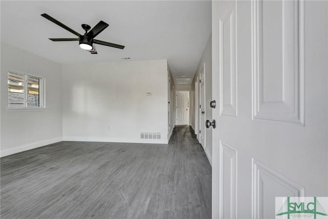 spare room featuring dark wood-type flooring and ceiling fan