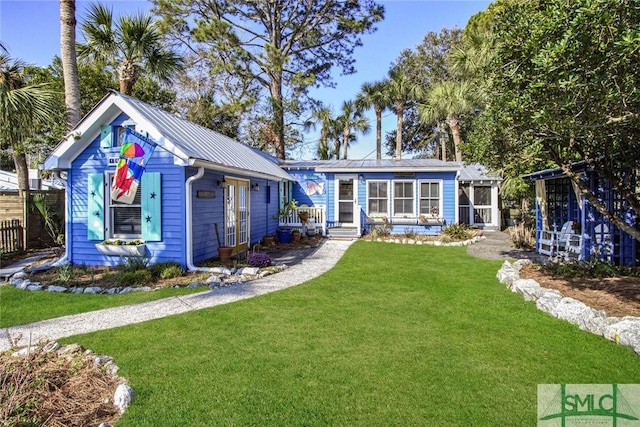 back of house with an outbuilding, a yard, and a sunroom