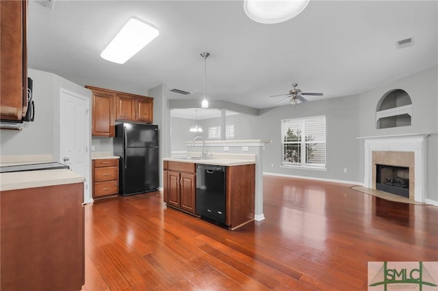 kitchen featuring sink, a premium fireplace, ceiling fan, dark hardwood / wood-style floors, and black appliances