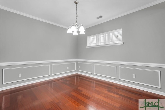 unfurnished room with hardwood / wood-style flooring, crown molding, and a notable chandelier