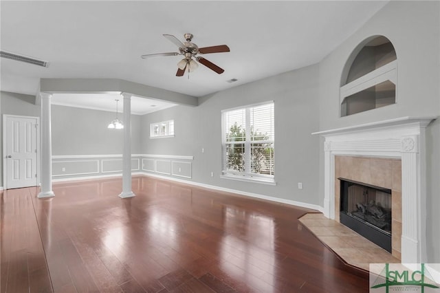 unfurnished living room with ornate columns, a tile fireplace, and light hardwood / wood-style floors