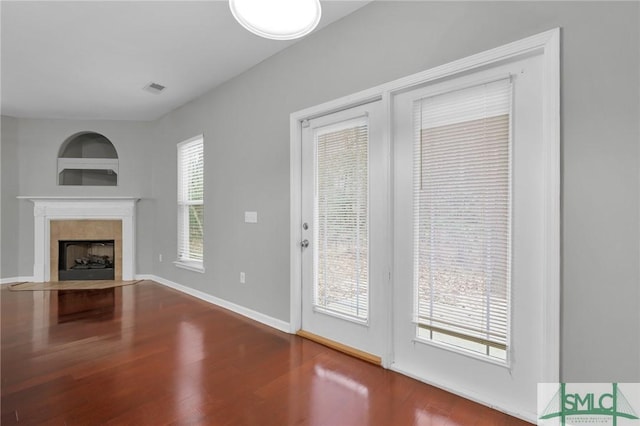 doorway to outside featuring plenty of natural light, hardwood / wood-style floors, and a tile fireplace