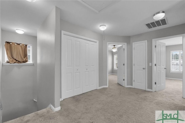 unfurnished bedroom featuring light carpet and a closet