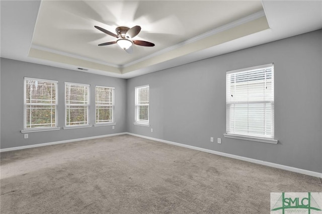 unfurnished room featuring carpet flooring, ornamental molding, and a tray ceiling