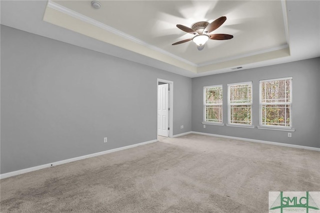 carpeted spare room featuring crown molding, ceiling fan, and a tray ceiling