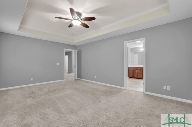 interior space with ornamental molding, ceiling fan, and a tray ceiling