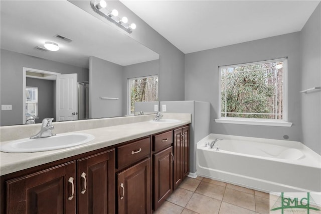 bathroom with vanity, tile patterned floors, and a tub to relax in