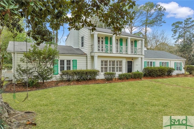 back of property with a balcony and a yard