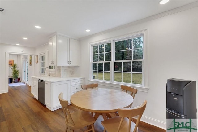 kitchen with dishwasher, sink, white cabinets, dark hardwood / wood-style flooring, and crown molding