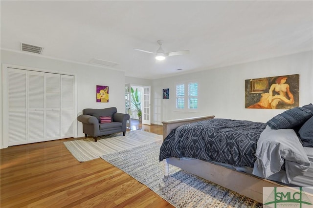 bedroom with hardwood / wood-style flooring, ceiling fan, and a closet