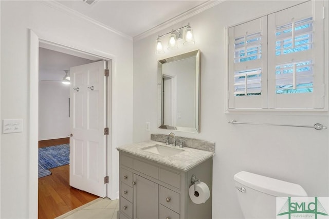 bathroom with vanity, hardwood / wood-style flooring, ornamental molding, and toilet