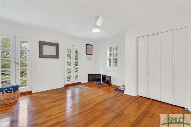 interior space with light hardwood / wood-style flooring, ceiling fan, access to exterior, french doors, and a closet