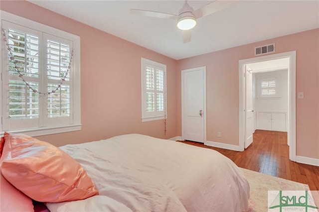 bedroom with multiple windows, light hardwood / wood-style flooring, and ceiling fan