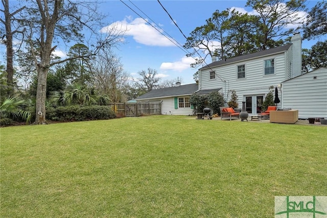 back of house featuring a yard, outdoor lounge area, and french doors