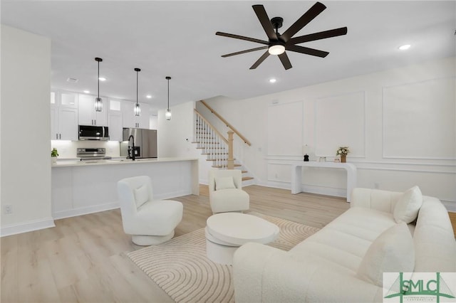 living room featuring ceiling fan and light hardwood / wood-style floors