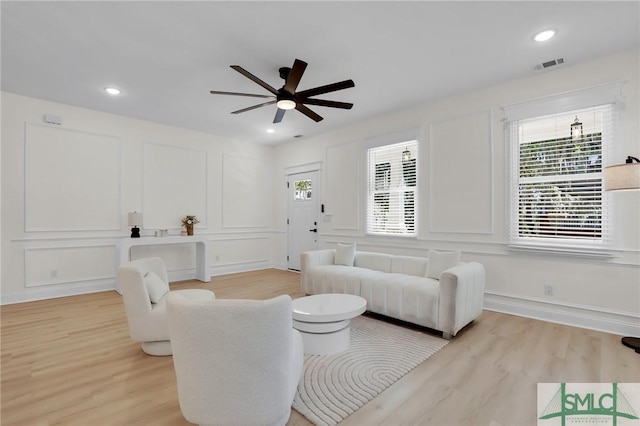 living room featuring ceiling fan and light hardwood / wood-style floors