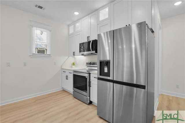 kitchen featuring white cabinetry, stainless steel appliances, and light wood-type flooring