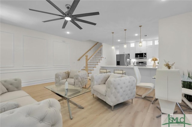 living room featuring ceiling fan and light hardwood / wood-style flooring