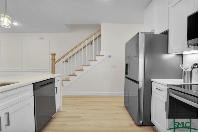 kitchen with white cabinetry, decorative light fixtures, dishwasher, stainless steel electric stove, and light hardwood / wood-style floors