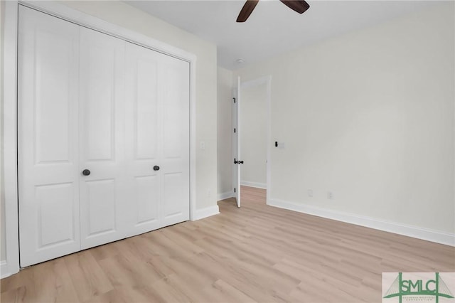 unfurnished bedroom with ceiling fan, a closet, and light wood-type flooring