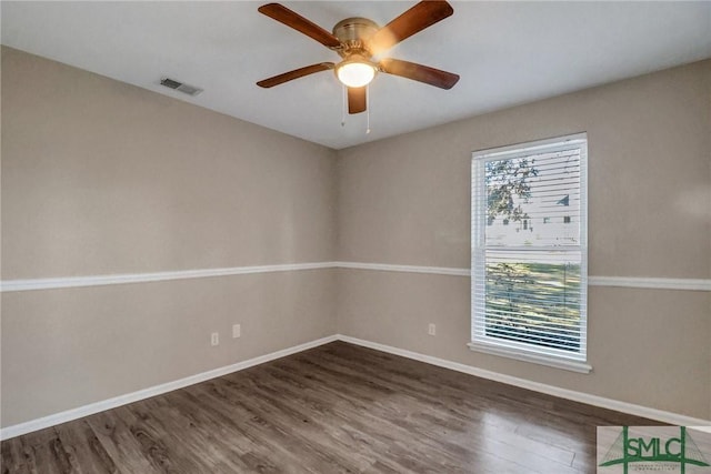 empty room with dark hardwood / wood-style floors and ceiling fan