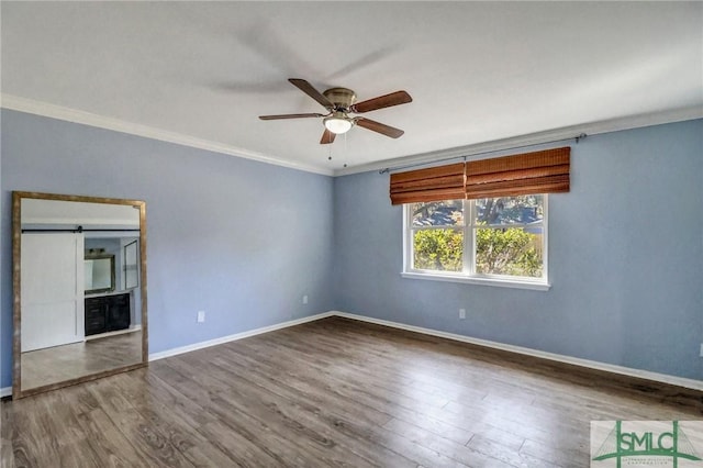 spare room featuring wood-type flooring, ornamental molding, and ceiling fan