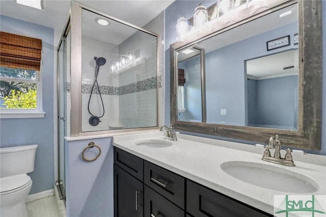 bathroom with vanity, toilet, and a shower with shower door