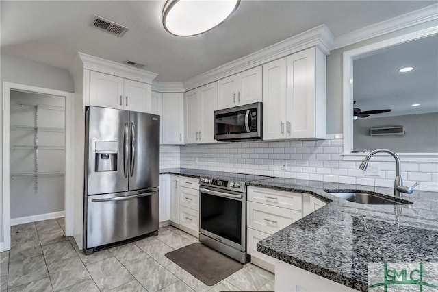 kitchen featuring stainless steel appliances, white cabinetry, sink, and dark stone countertops