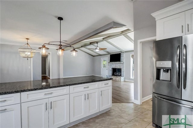 kitchen featuring ceiling fan, white cabinetry, stainless steel refrigerator with ice dispenser, decorative light fixtures, and dark stone counters