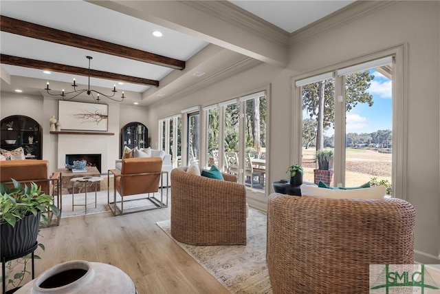 living room with a notable chandelier, crown molding, light hardwood / wood-style flooring, and beamed ceiling