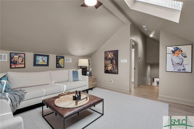 living room with ceiling fan, vaulted ceiling, and light hardwood / wood-style flooring