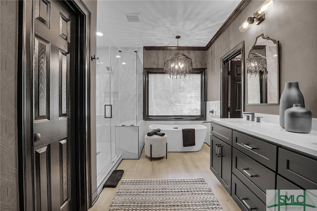 bathroom featuring hardwood / wood-style flooring, vanity, ornamental molding, independent shower and bath, and a chandelier