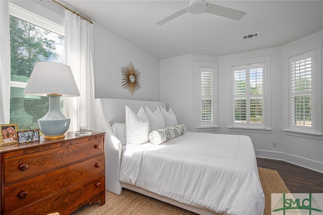 bedroom with ceiling fan, wood-type flooring, and multiple windows