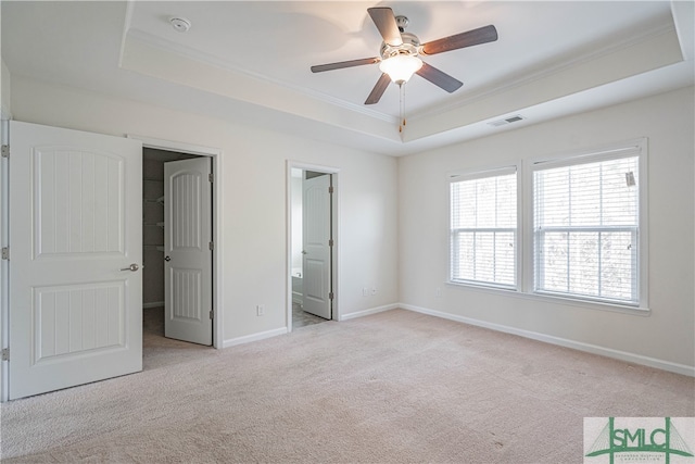 230 Ventura Pl, Pooler, GA 31322 - unfurnished bedroom with connected bathroom, crown molding, a walk in closet, a raised ceiling, and light colored carpet