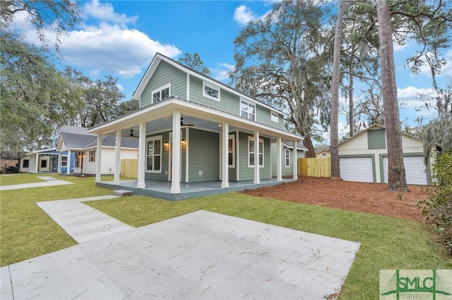 view of front of property with a garage, an outdoor structure, a front yard, and covered porch