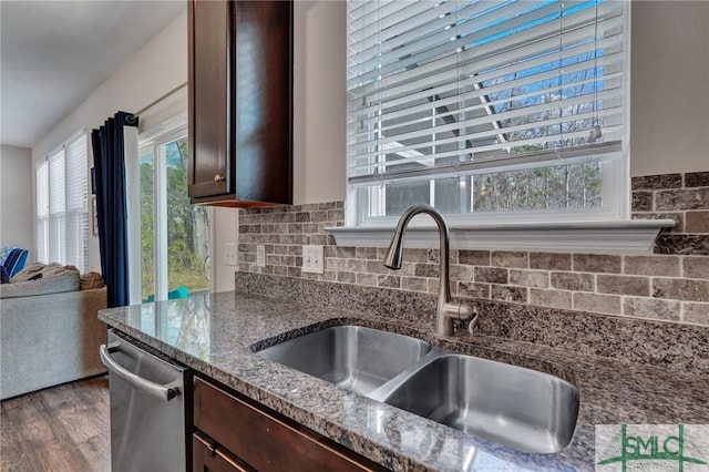 kitchen featuring sink, dark wood-type flooring, stone counters, dark brown cabinetry, and stainless steel dishwasher