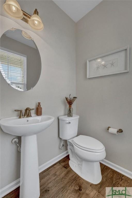 bathroom with toilet and hardwood / wood-style floors