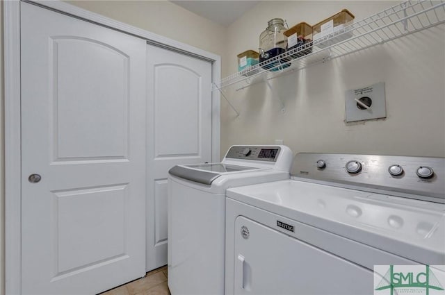 laundry room with washing machine and dryer and light tile patterned floors