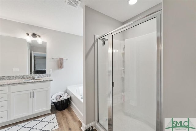 601 Meloney Dr, Hinesville, GA 31313 - bathroom with vanity, independent shower and bath, and wood-type flooring