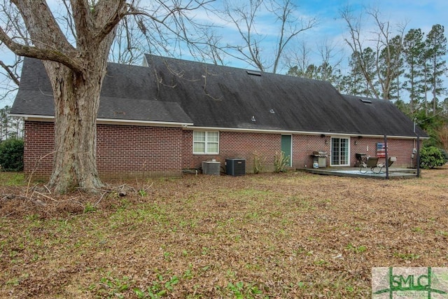 rear view of property with a patio and a lawn