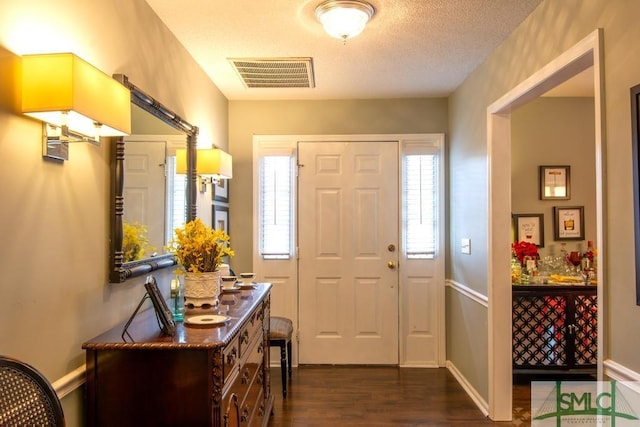 entrance foyer with dark hardwood / wood-style floors and a textured ceiling