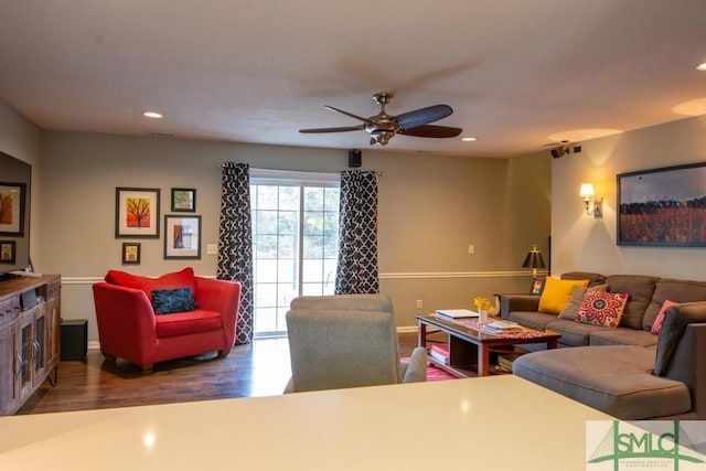 living room featuring dark wood-type flooring and ceiling fan