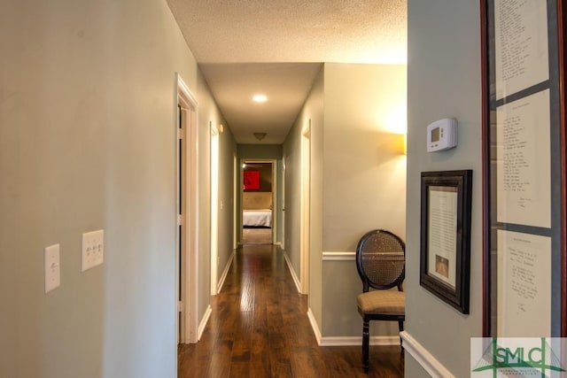 corridor with dark wood-type flooring and a textured ceiling